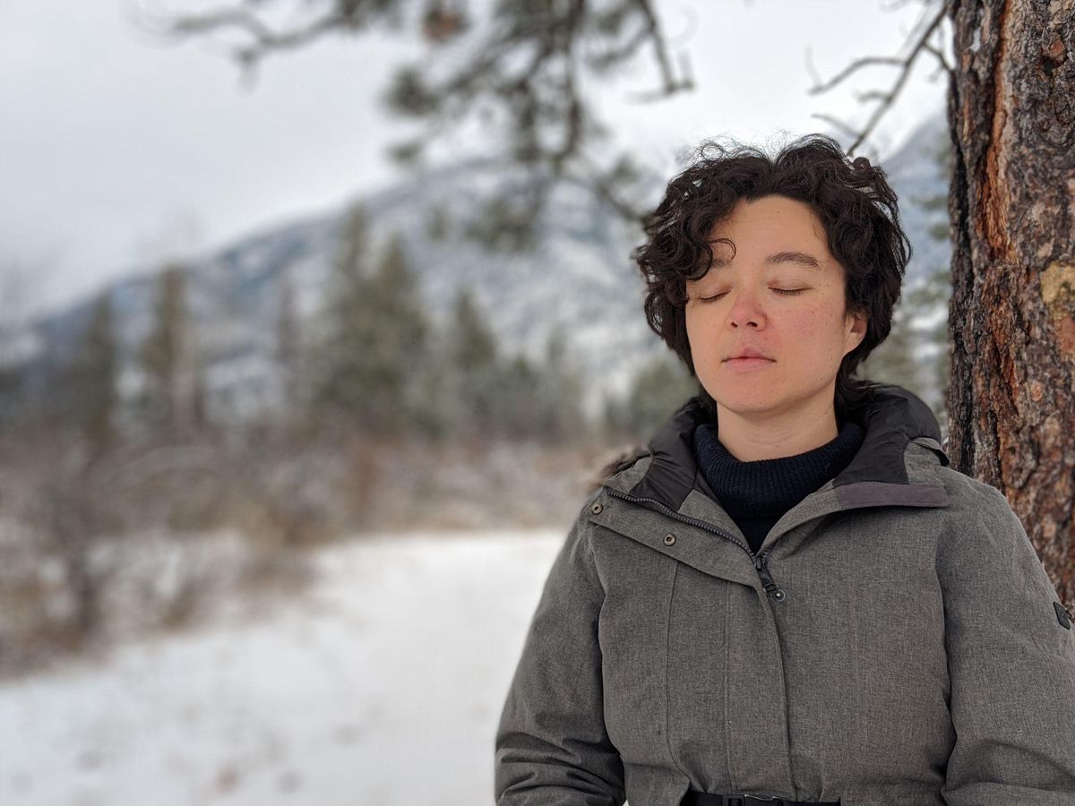 Feel guilty spending money on yourself: woman pausing with eyes closed in a snowy forest